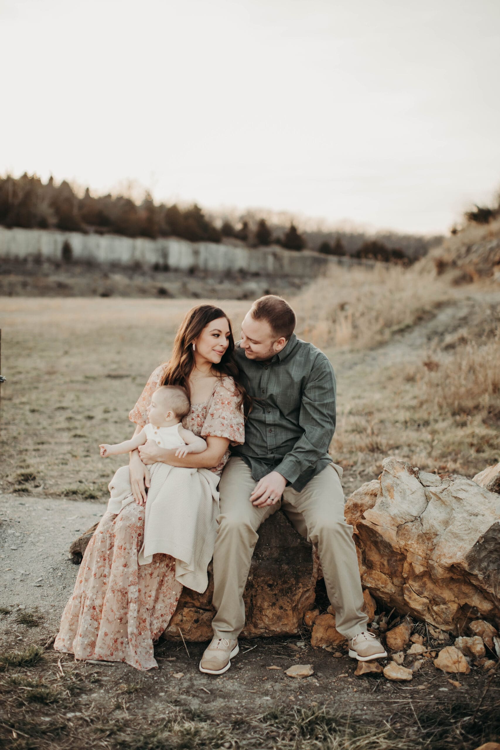 Family laughing and posing together outdoors during a sunset photo session.