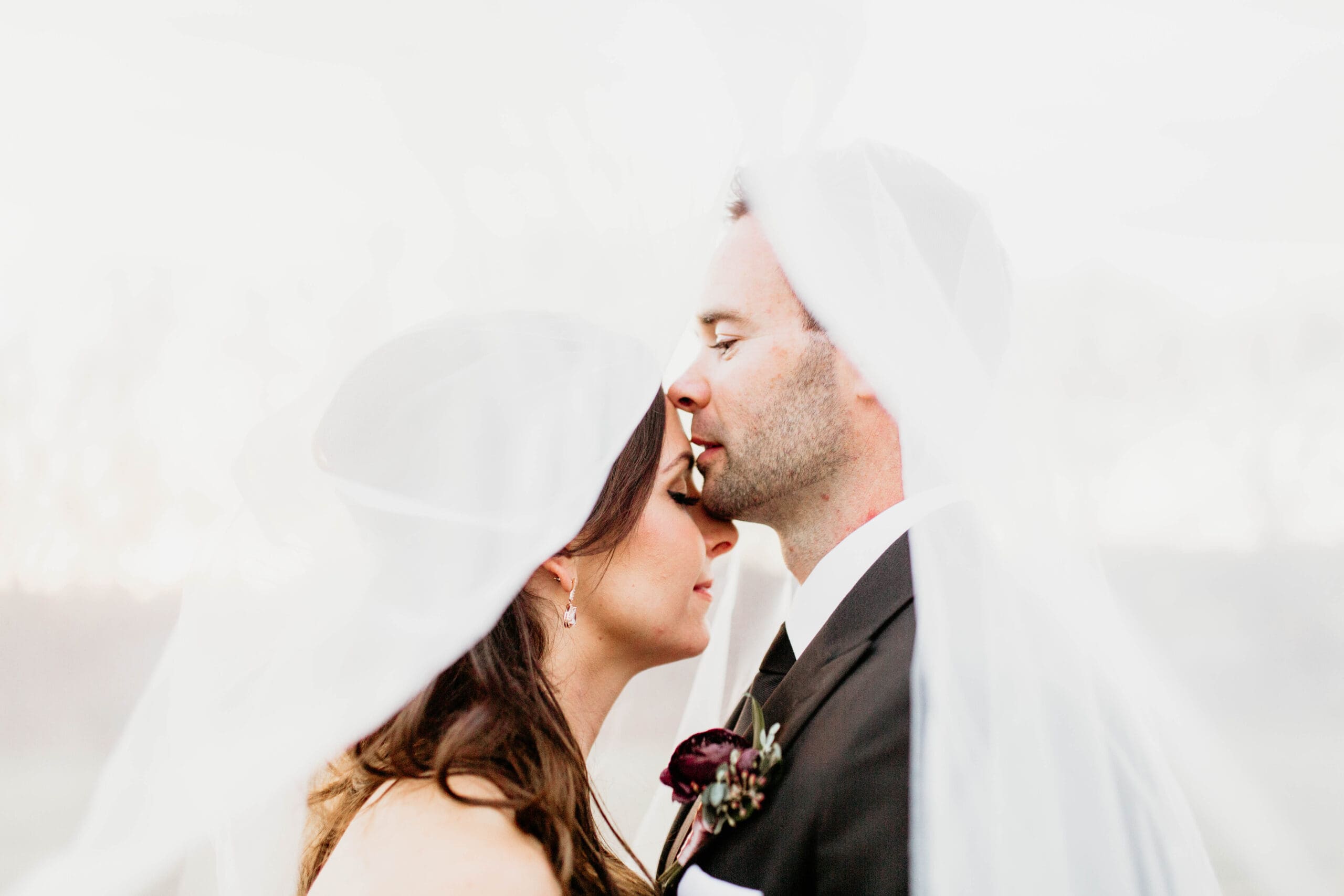 romantic first look bride and groom under veil.