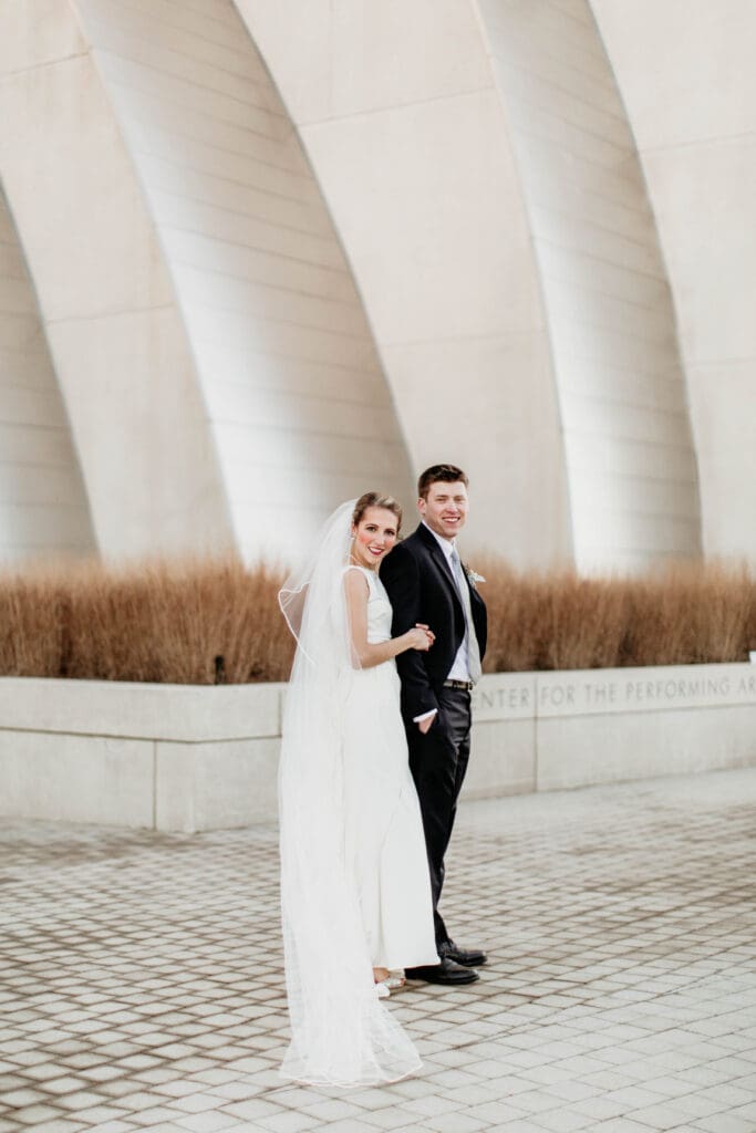 bride and groom standing in front of Kauffman Performing Arts