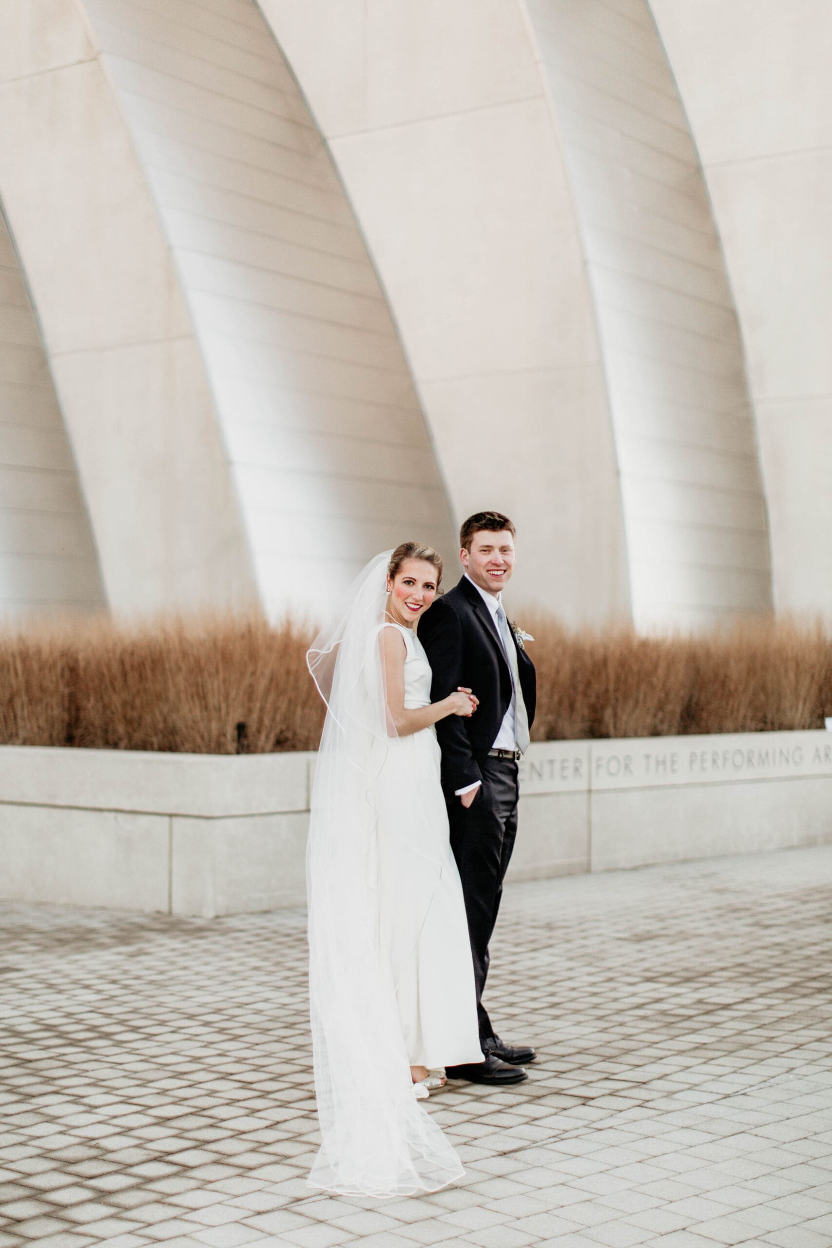 bride and groom standing in front of Kauffman Performing Arts