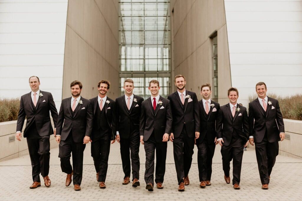 Groomsmen walking together at the Kauffman Center of Performing Arts. 