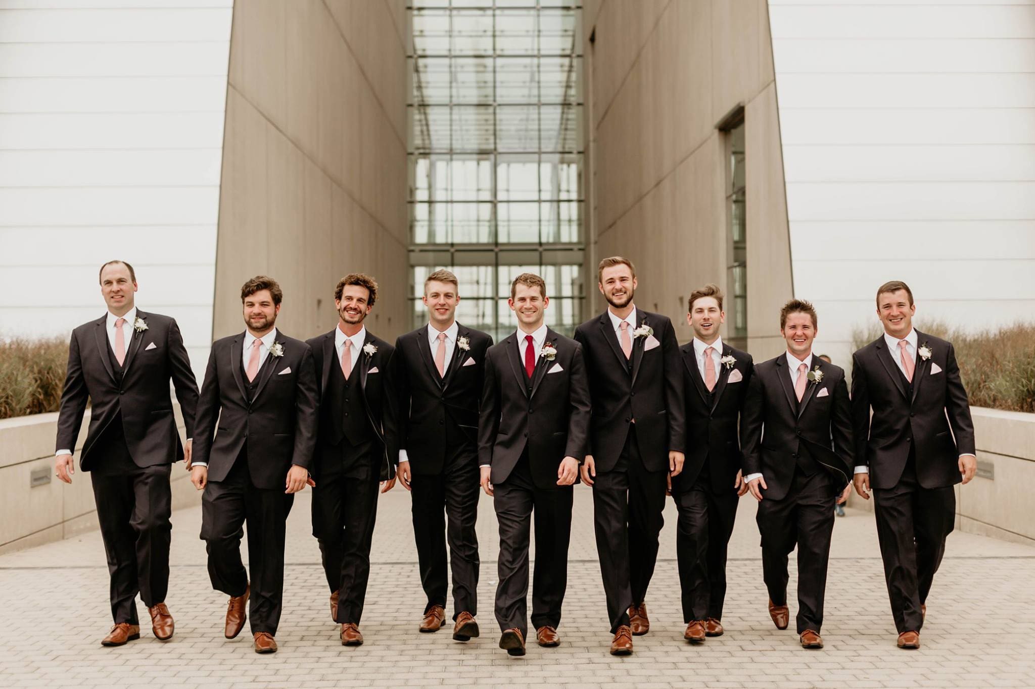 Groomsmen walking in front of Kauffman Center of Performing Arts.