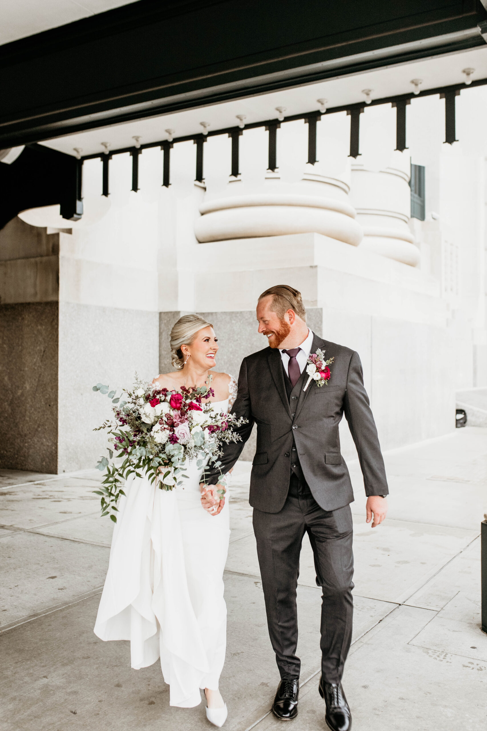 Couple walking hand in hand after wedding.