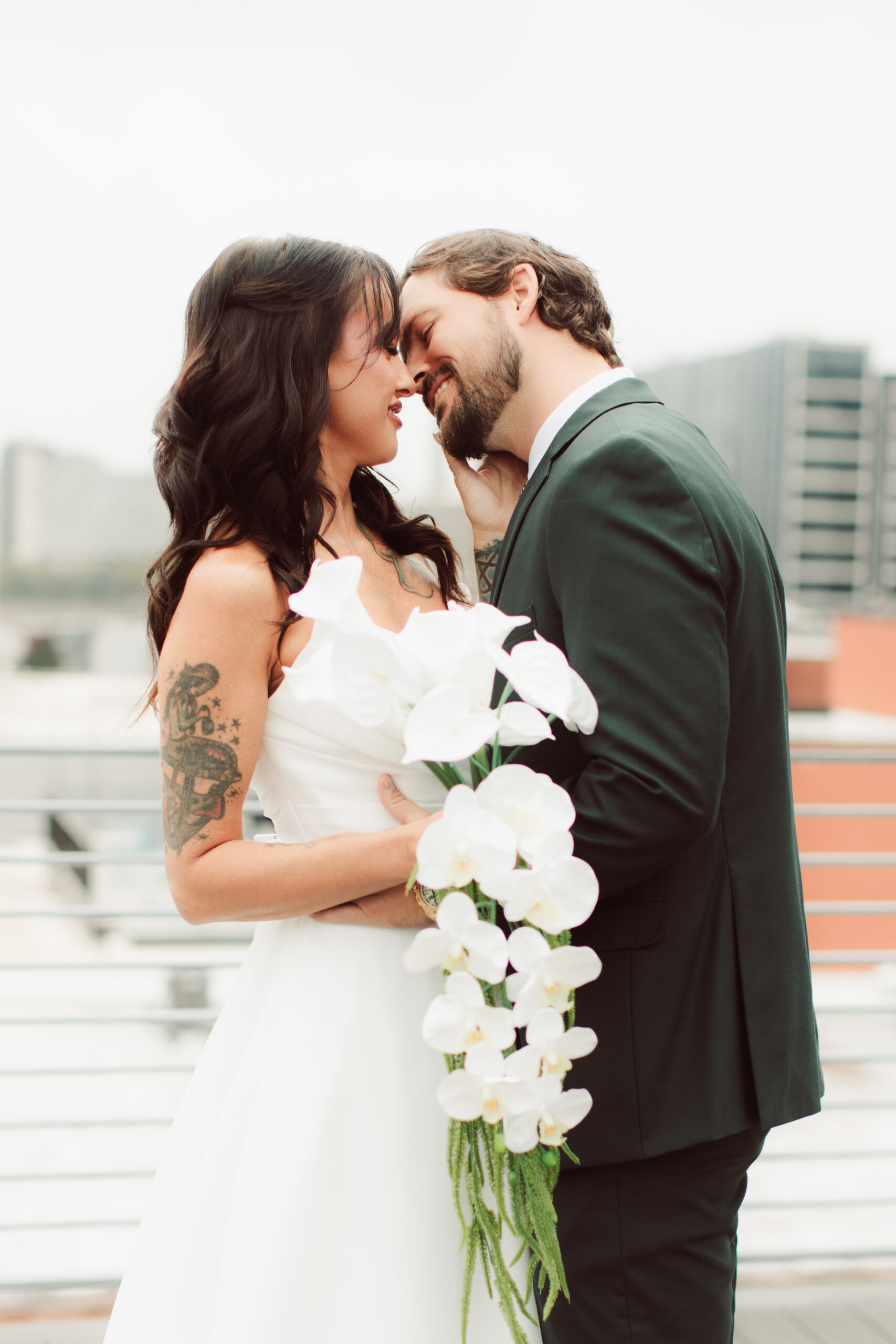 Bride and groom kissing at kansas city skyline
