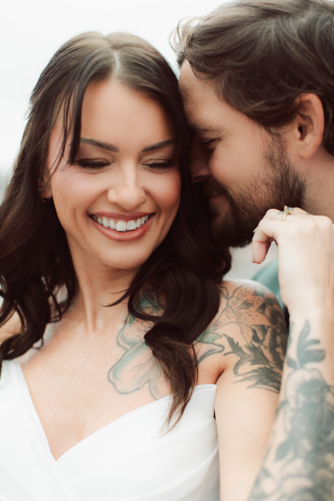 Bride and groom snuggled in close.