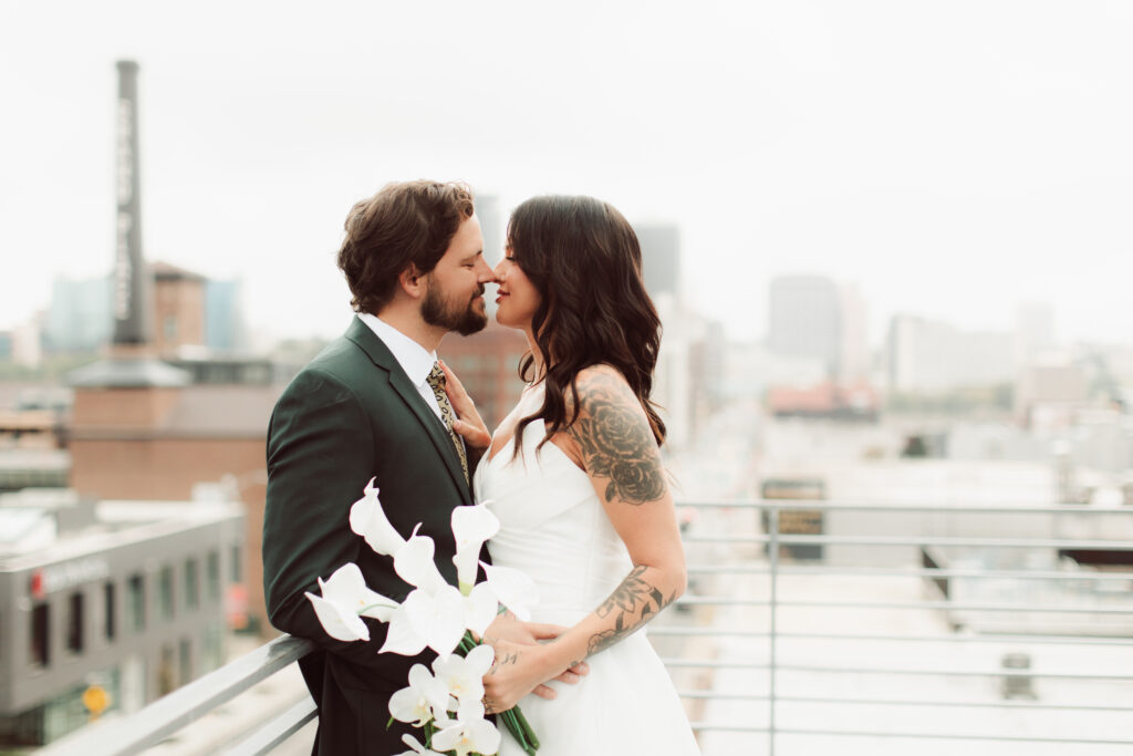 Bride and groom almost kissing on rooftop
