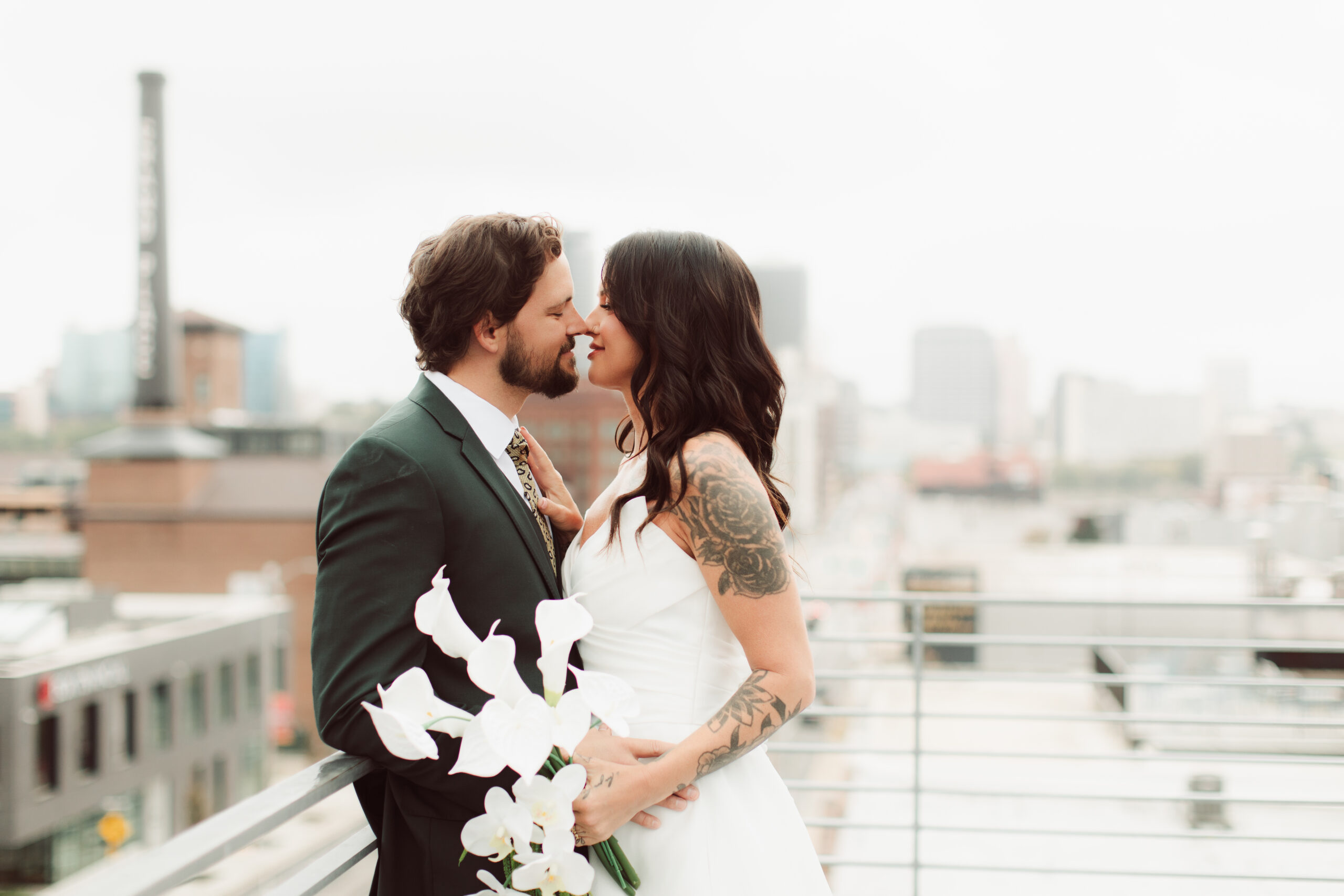 Bride and groom almost kissing on rooftop