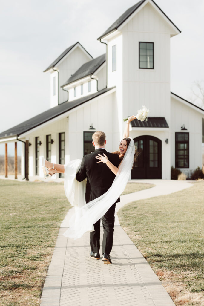 Groom. holding bride during couples portraits 