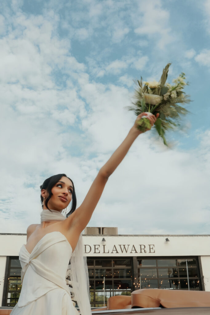 Bride holding bouquet in front of The Delaware wedding venue captured by Atlanta wedding photographer