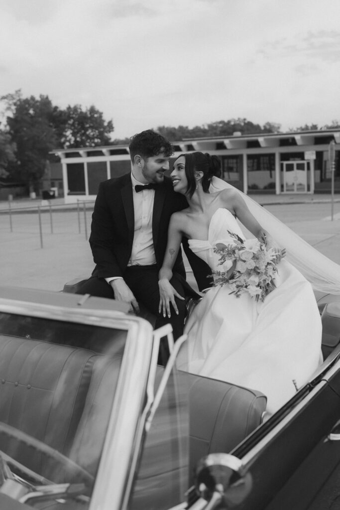 Bride and groom sitting in vintage convertible on wedding day captured by Atlanta wedding photographer