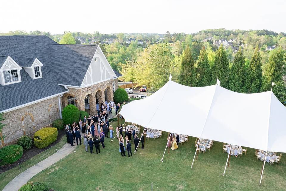Outdoor ceremony setup at The Manor Golf & Country Club wedding venue featuring floral aisle, white chairs, and scenic lawn in Alpharetta Georgia