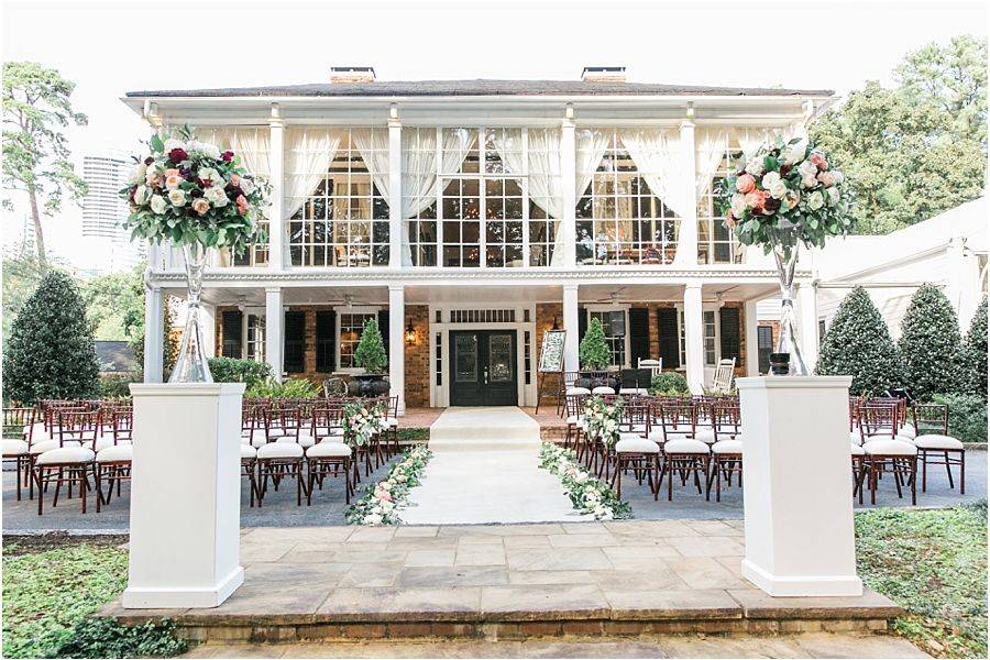 Outdoor ceremony setup at The Estate Atlanta wedding venue featuring historic mansion backdrop, floral aisle design, and elegant garden ceremony space in Midtown Atlanta Georgia